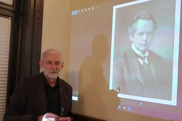 Na zdjęciu mężczyzna, a w tle wyświetlana prezentacja