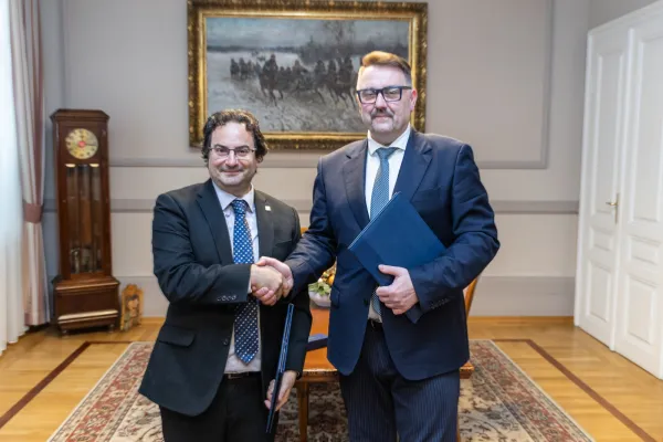 Na zdjęciu stojący ludzie 