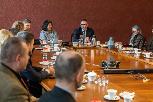 Na zdjęciu siedzący ludzie 