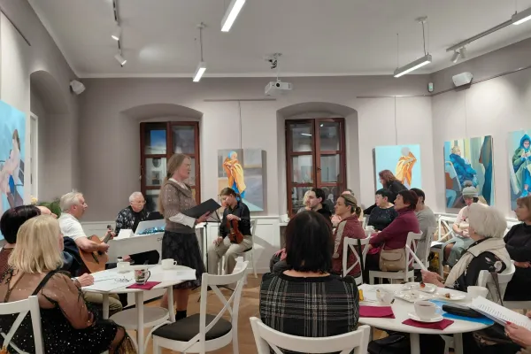 Na zdjęciu stojący ludzie 