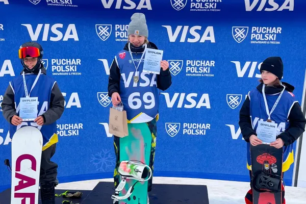 Na zdjęciu stojący ludzie 