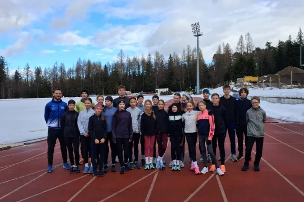 Na zdjęciu stojący ludzie 