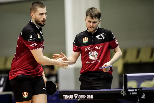 Na zdjęciu stojący ludzie 