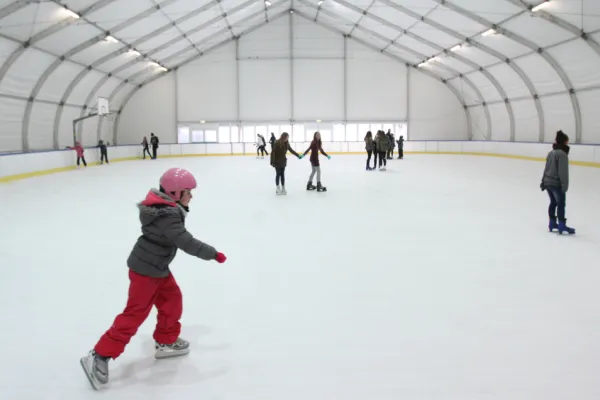 Na zdjęciu łyżwiarze na lodowisku 