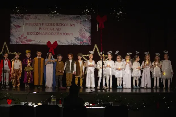 Na zdjęciu stojący ludzie 