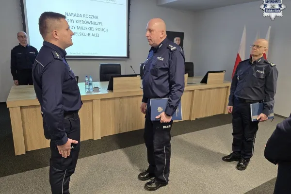 Na zdjęciu stojący ludzie 