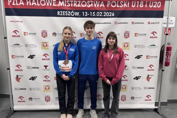 Na zdjęciu stojący ludzie 