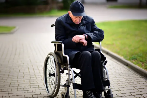 Na zdjęciu straszy człowiek na wózku inwalidzkim 