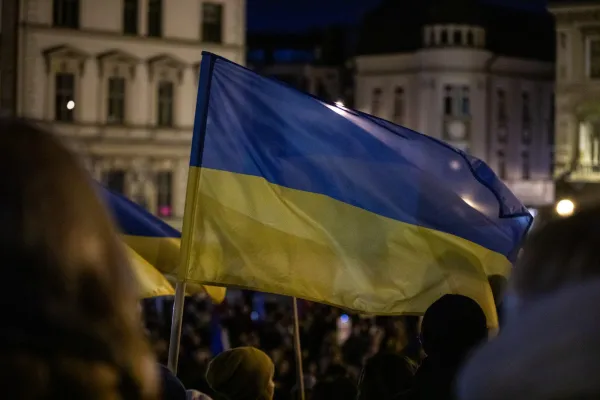 Na zdjęciu stojący ludzie 