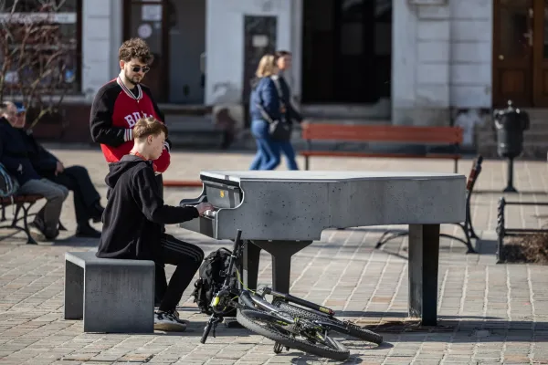 Na zdjęciu fortepian i grający na nim mężczyzna