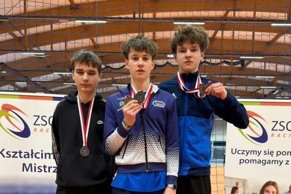 Na zdjęciu stojący ludzie 