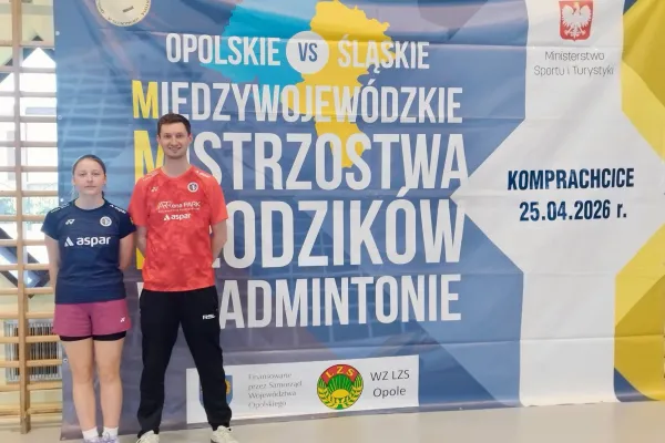 Na zdjęciu stojący ludzie 