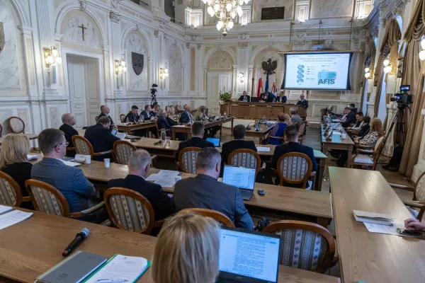 Na zdjęciu siedzący ludzie 