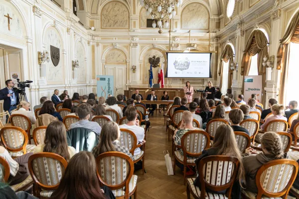 Na zdjęciu siedzący ludzie 