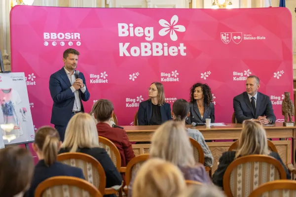 Na zdjęciu stojący ludzie 