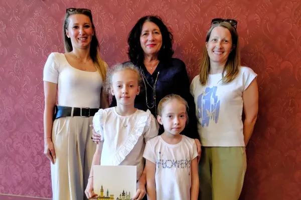 Na zdjęciu stojący ludzie 