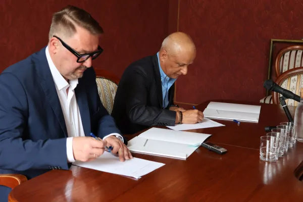 Na zdjęciu siedzący ludzie 
