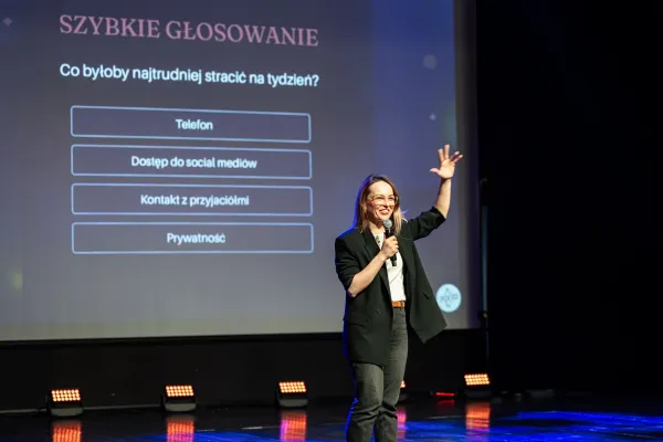 Na zdjęciu stojący ludzie 