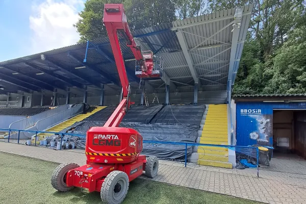Na zdjęciu zwyżka podczas remontu dachu nad trybunami na stadionie