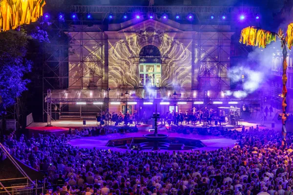 Na zdjęciu rozświetlony, otoczony publicznością Teatr Polski podczas koncertu w oknie