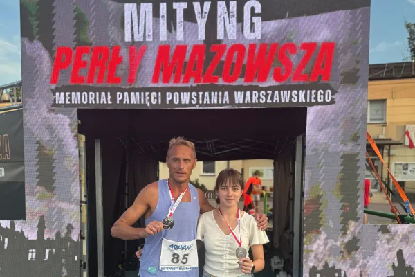 Na zdjęciu stojący ludzie 